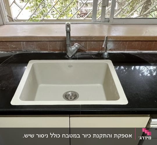 התקנת כיור מטבח בהיר בתוך משטח שיש שחור